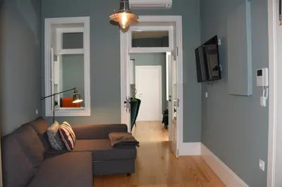 a living room with a couch and a tv at Porto Traveler Apartment in Porto