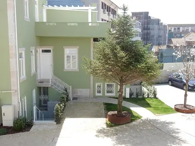 a green house with a tree in front of it at Porto Traveler Apartment in Porto