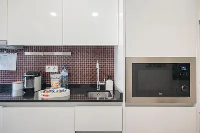 a kitchen with a sink and a microwave at Central Luxury apartment w AC Downtown and Metro in Porto