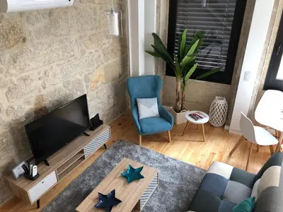a living room with a television and a blue chair at URBAN VIEWS Terrace - Duplex Apartment 