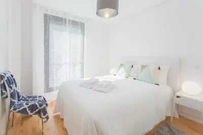 a white bedroom with a white bed and a blue chair at URBAN VIEWS Terrace - Duplex Apartment 