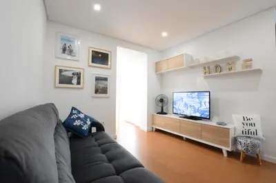 a living room with a couch and a flat screen tv at LUXURY Golden River Apartment - In the Heart of city center and wine cellars in Vila Nova de Gaia