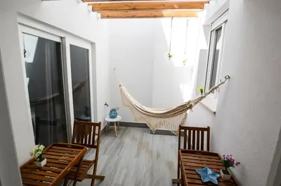 a room with a hammock and two chairs and a table at LUXURY Golden River Apartment - In the Heart of city center and wine cellars in Vila Nova de Gaia