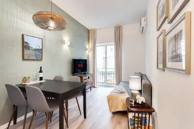 a living room with a table and chairs in a room at Central Porto 1BR Apartment - Oporto Bridges in Porto