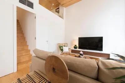 a living room with a couch and a tv at BmyGuest Collection - Downtown Mezzanine Apartment in Porto