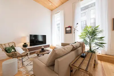 a living room with a couch and a tv at BmyGuest Collection - Downtown Mezzanine Apartment in Porto