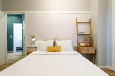 a bedroom with a large white bed with a yellow pillow at Porto Haven - Downtown by the Metro in Porto