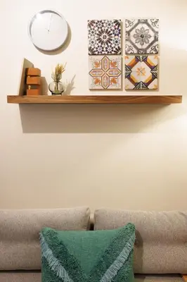 a shelf above a couch with a clock on a wall at Porto Haven - Downtown by the Metro in Porto