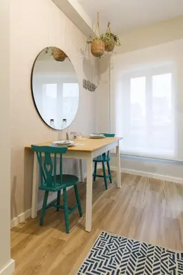 a dining room table with two green chairs and a mirror at Porto Haven - Downtown by the Metro in Porto