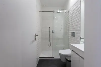 a white bathroom with a shower and a toilet at LovelyStay - Rico's Apartment - Almada 2º F in Porto