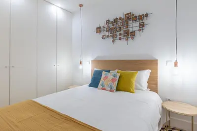 a bedroom with a white bed with a wooden headboard at Porto Blue Terrace in Porto