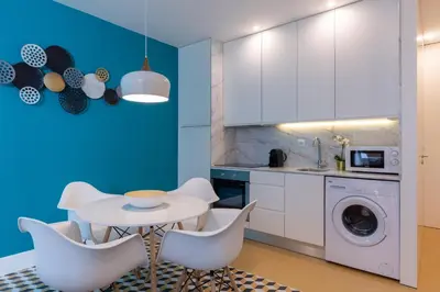 a kitchen with white cabinets and a table and chairs at Porto Blue Terrace in Porto