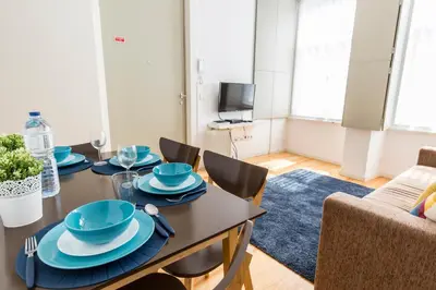 a dining room with a table with blue dishes on it at Downtown Porto Bonfim Studio Apt in Porto