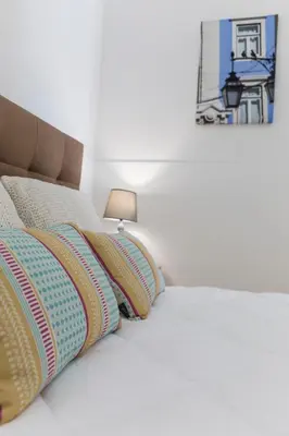 a bed with two pillows and a lamp on it at Downtown Porto Bonfim Studio Apt in Porto