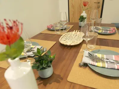 a wooden table with plates and wine glasses on it at FLH Porto Modern Apartment in Porto