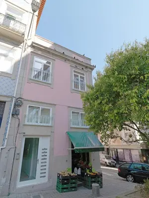 a pink building with a flower market in front of it at FLH Porto Modern Apartment in Porto