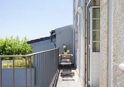 a small balcony with a table on the side of a building at Liiiving in Porto | Central Secret Balcony in Porto