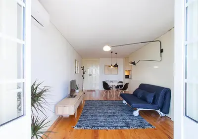 a living room with a blue couch and a table at Liiiving in Porto | Central Secret Balcony in Porto