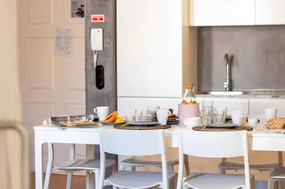 a kitchen with a white table with white chairs at LovelyStay - Dirk Apartment Almada 3º T in Porto