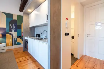 a kitchen with white cabinets and a wooden floor at LovelyStay - Dirk Apartment - Almada 4º F in Porto
