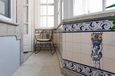 a room with a chair and a tiled wall at AD Apartment - Solar da Avenida in Porto