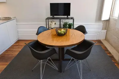 a wooden table with chairs and a bowl of fruit on it at AD Apartment - Solar da Avenida in Porto