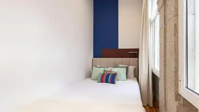 a bed in a room with a window at LovelyStay - Allderman Apartment - Almada 1º T in Porto
