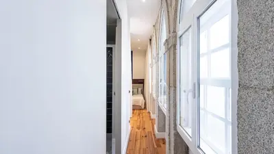 a hallway with white walls and a window at LovelyStay - Allderman Apartment - Almada 1º T in Porto