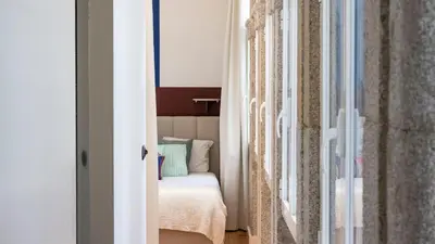a small bedroom with a bed and curtains at LovelyStay - Allderman Apartment - Almada 1º T in Porto