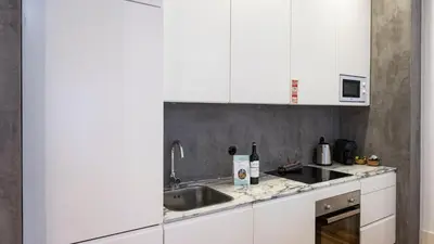 a kitchen with white cabinets and a sink at LovelyStay - Allderman Apartment - Almada 1º T in Porto