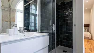 a bathroom with a sink and a glass shower at LovelyStay - Allderman Apartment - Almada 1º T in Porto