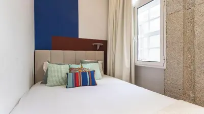 a bedroom with a bed with pillows and a window at LovelyStay - Allderman Apartment - Almada 1º T in Porto