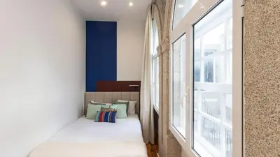 a small bedroom with a bed next to a window at LovelyStay - Allderman Apartment - Almada 1º T in Porto