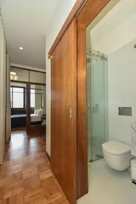 a bathroom with a toilet and a glass shower door at Republica 157 Guest House in Porto