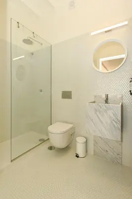 a bathroom with a toilet and a glass shower at Republica 157 Guest House in Porto