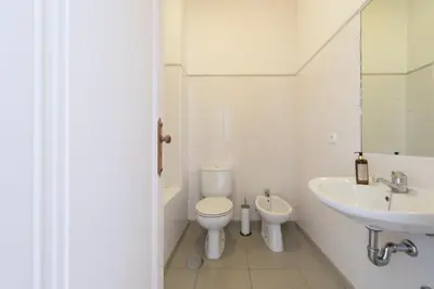 a white bedroom with a large bed and a table at LovelyStay - Flower Stylish Apartment in Porto