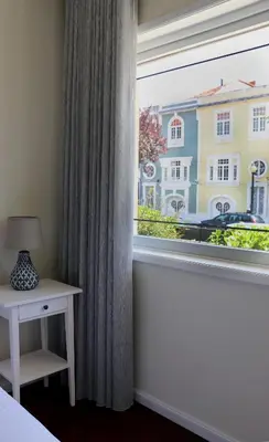a bedroom with a window and a table with a lamp at Porto Patricio Apartments in Porto