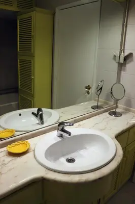 a bathroom counter with two sinks and a mirror at Porto Patricio Apartments in Porto