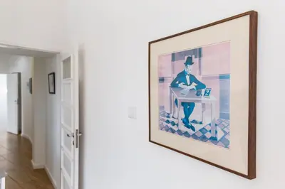 a framed painting of a man sitting at a table in a room at Porto Haven - Terrace Penthouse in Downtown in Porto