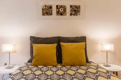 a bedroom with two lamps and a bed with yellow pillows at Porto Haven - Marquês Downtown in Porto