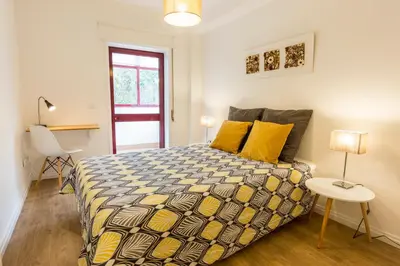 a bedroom with a bed with yellow pillows and a table at Porto Haven - Marquês Downtown in Porto