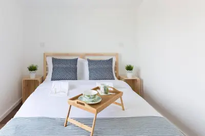 a bedroom with a bed with a wooden table at APOSENTUS - Your home at Pinheiro's Residence in Porto