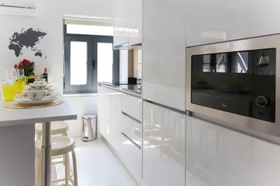 a white kitchen with a microwave and a counter at APOSENTUS - Your home at Pinheiro's Residence in Porto