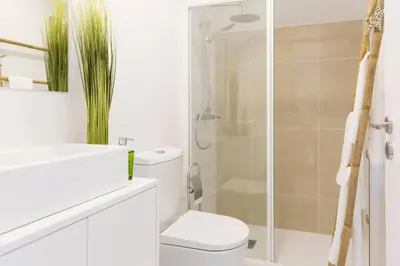 a white bathroom with a toilet and a shower at APOSENTUS - Your home at Pinheiro's Residence in Porto