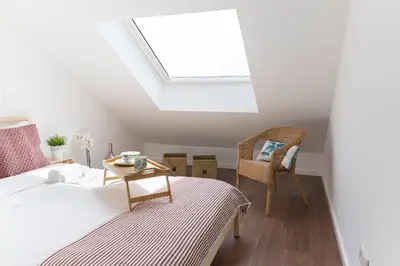 a bedroom with a bed and a skylight at APOSENTUS - Your home at Pinheiro's Residence in Porto