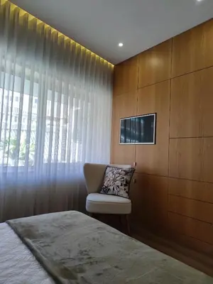 a bedroom with a bed and a chair next to a window at Trindade Apartments in Porto