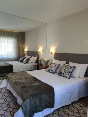 a hotel room with two beds and a mirror at Trindade Apartments in Porto