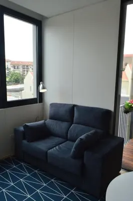 a blue couch in a living room with a window at Camões by Trindade Sweet Home in Porto