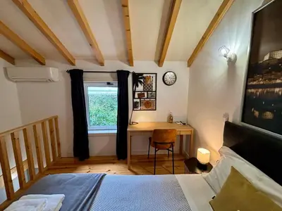 a bedroom with a desk and a bed and a window at Mezzanine cozy house in Porto