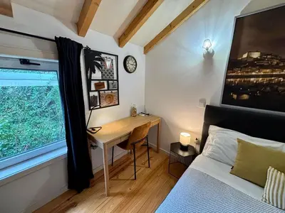 a bedroom with a desk and a bed and a window at Mezzanine cozy house in Porto